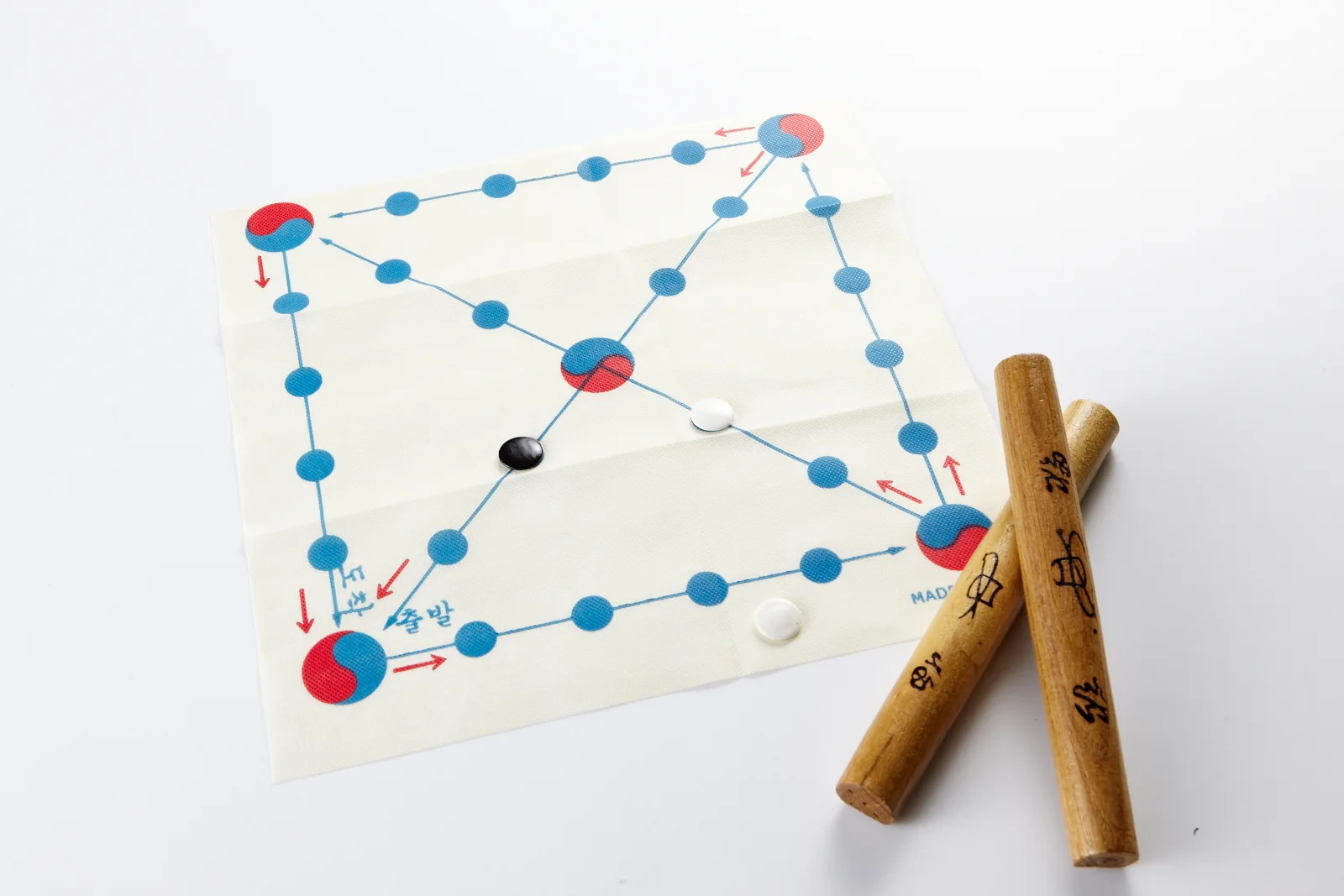 Yutnori sticks, tokens, and a game board arranged for play