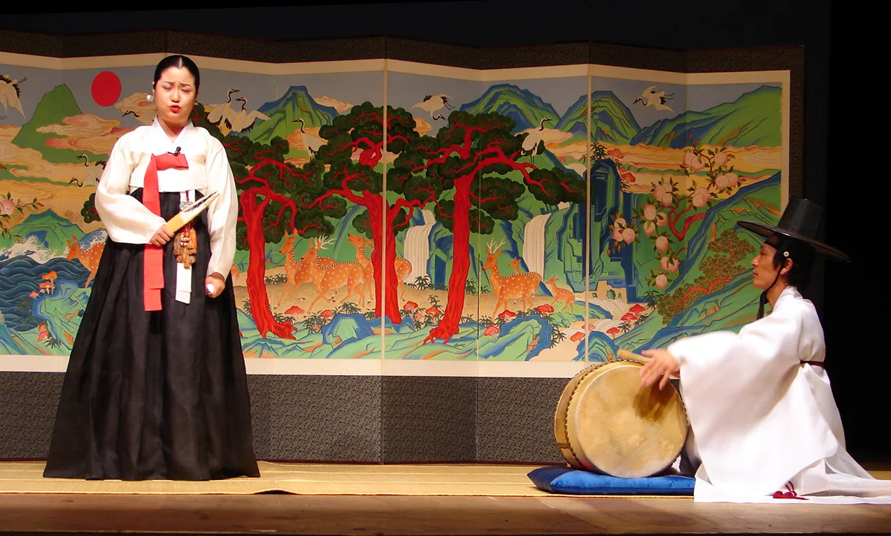A pansori singer and drummer performing together onstage at the Busan Cultural Center