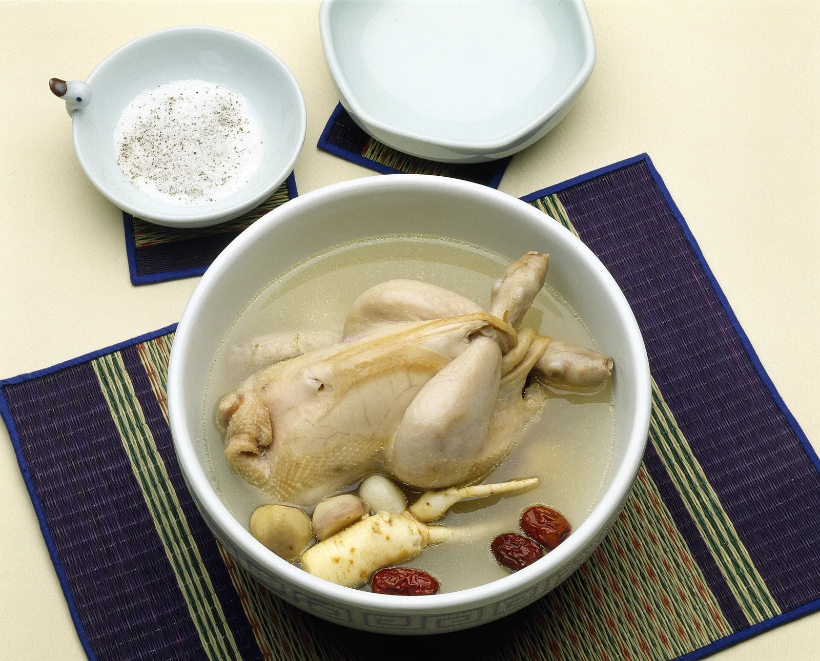 Korean samgyetang chicken soup with ginseng, garlic, and jujubes in a ceramic bowl