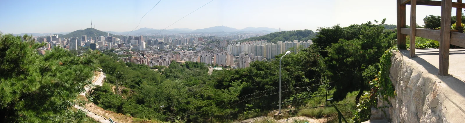 Wide view of the Seoul skyline and green hills photographed from Inwangsan