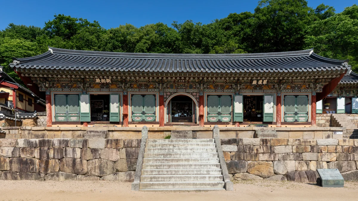 Front exterior and stone steps at Beomeosa Temple in Busan under a blue sky.